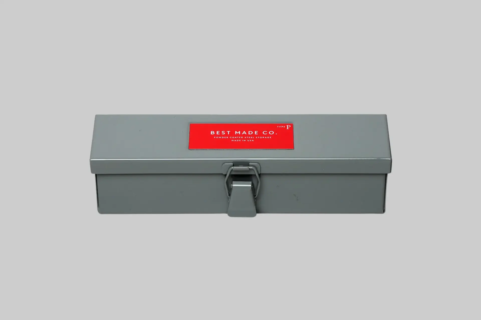 A minimalist, powder-coated Best Made Co. Type-P Strongbox on a workbench, showcasing its durable steel construction and heavy-duty latch. - Product Review