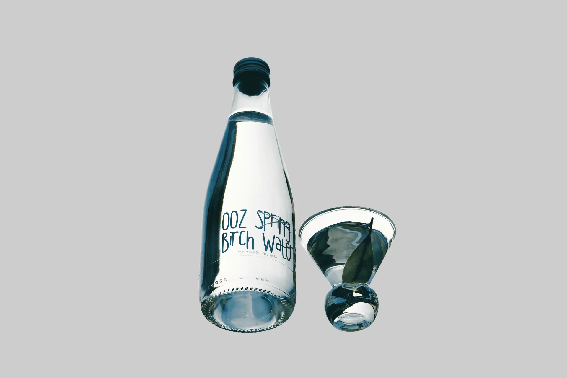 A glass bottle of OOZ Organic Birch Water against a clean background, showcasing its minimalist label and naturally clear, lightly golden birch sap. - Product Review